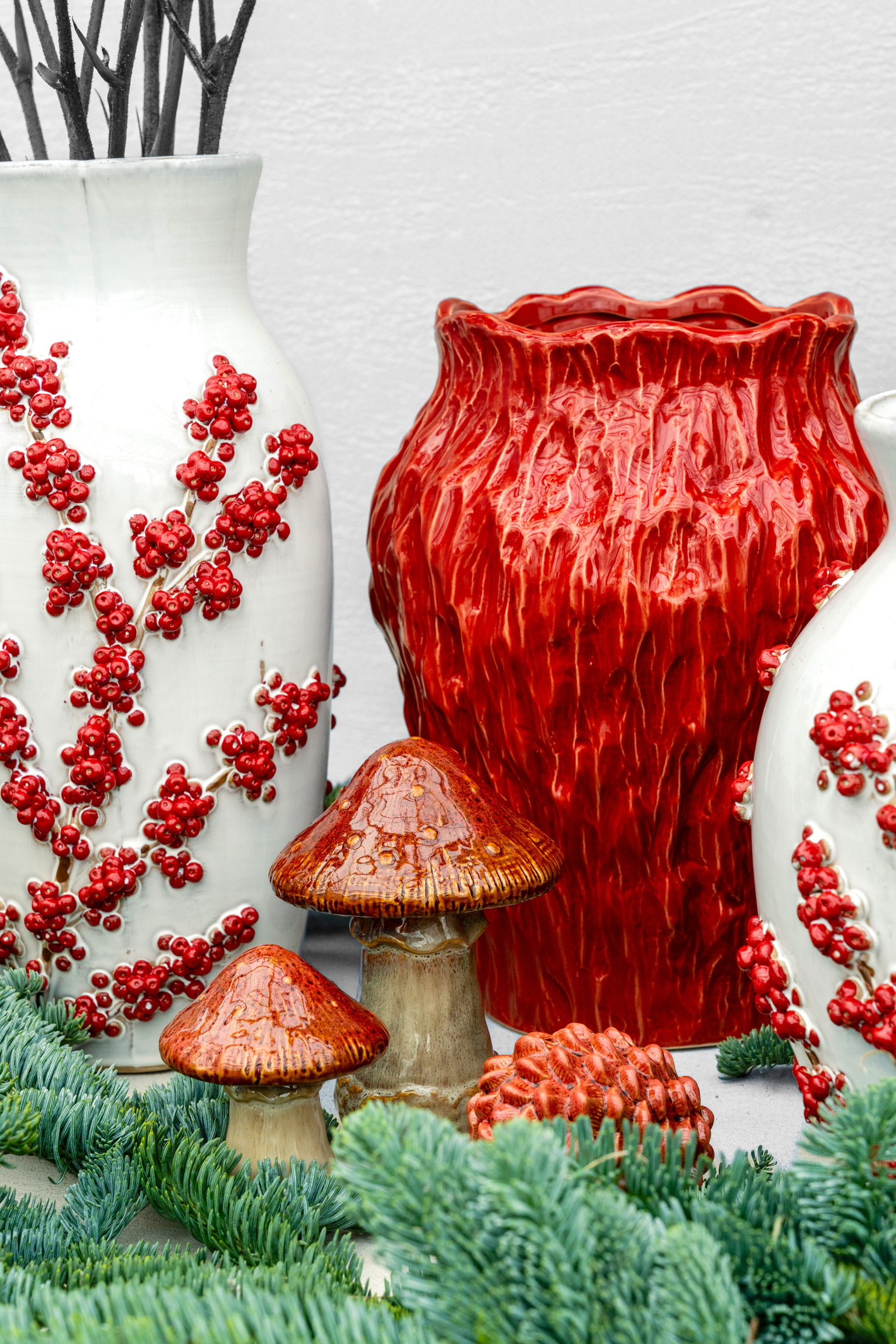 Rode vaas met rode bessen en twee paddenstoelen tussen groen mos, stilleven
