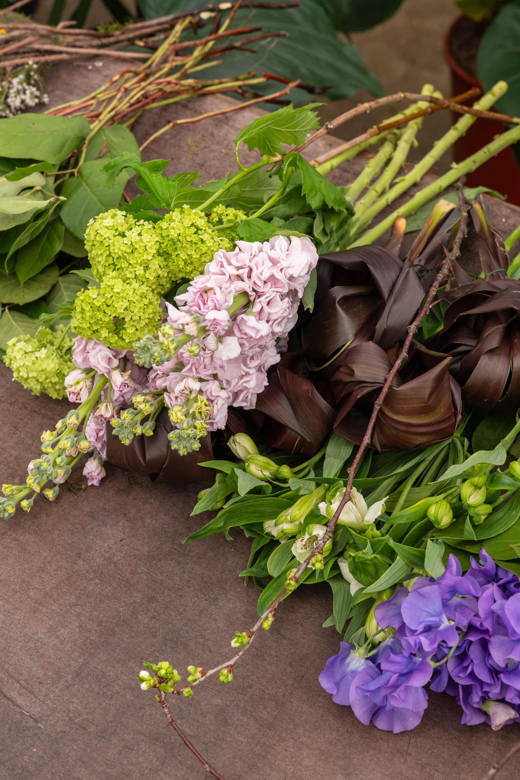 Boeket met paarse en roze bloemen en groen op bruine ondergrond