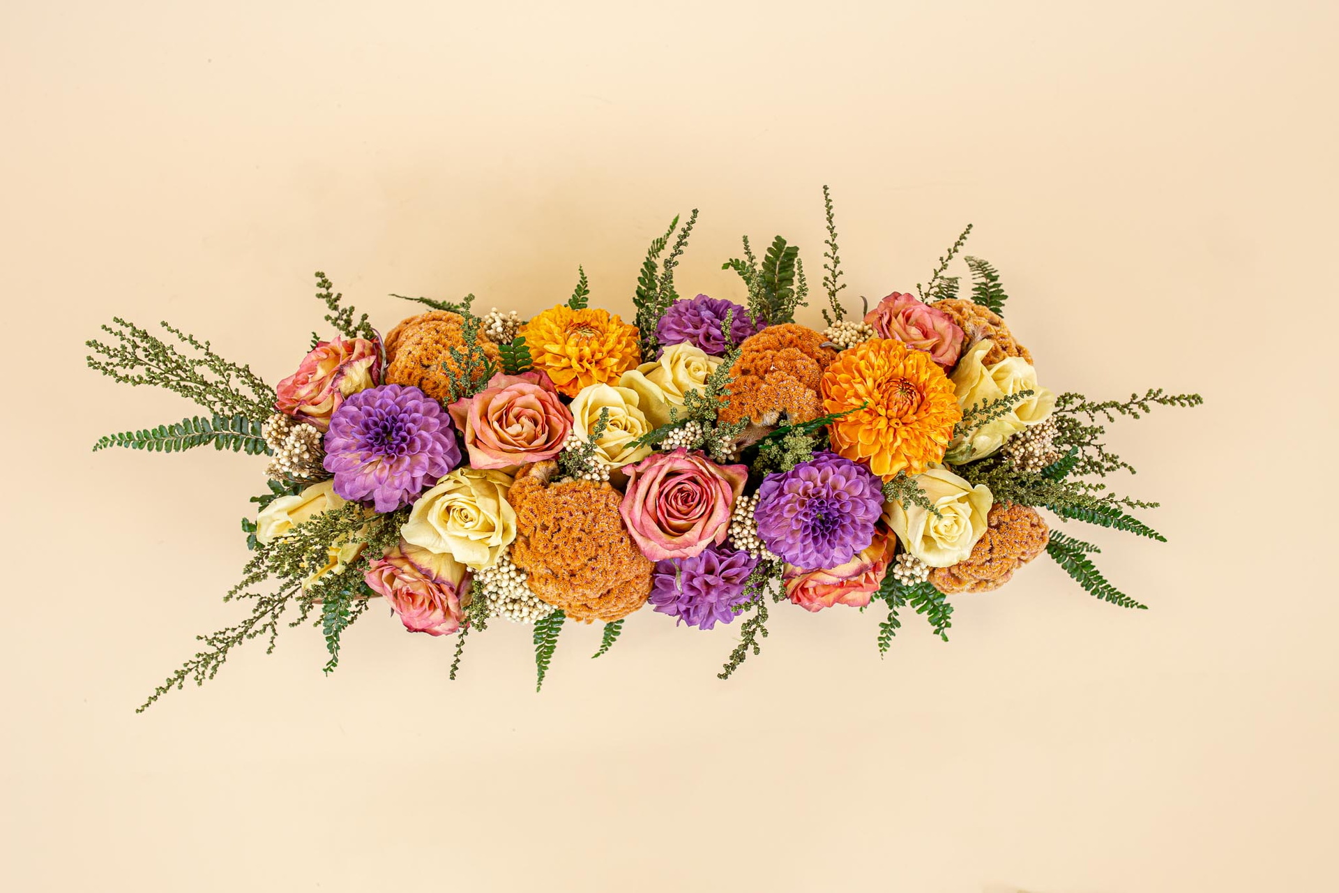 Kleurrijk bloemstuk met rozen en paarse bloemen op lichte achtergrond, foto