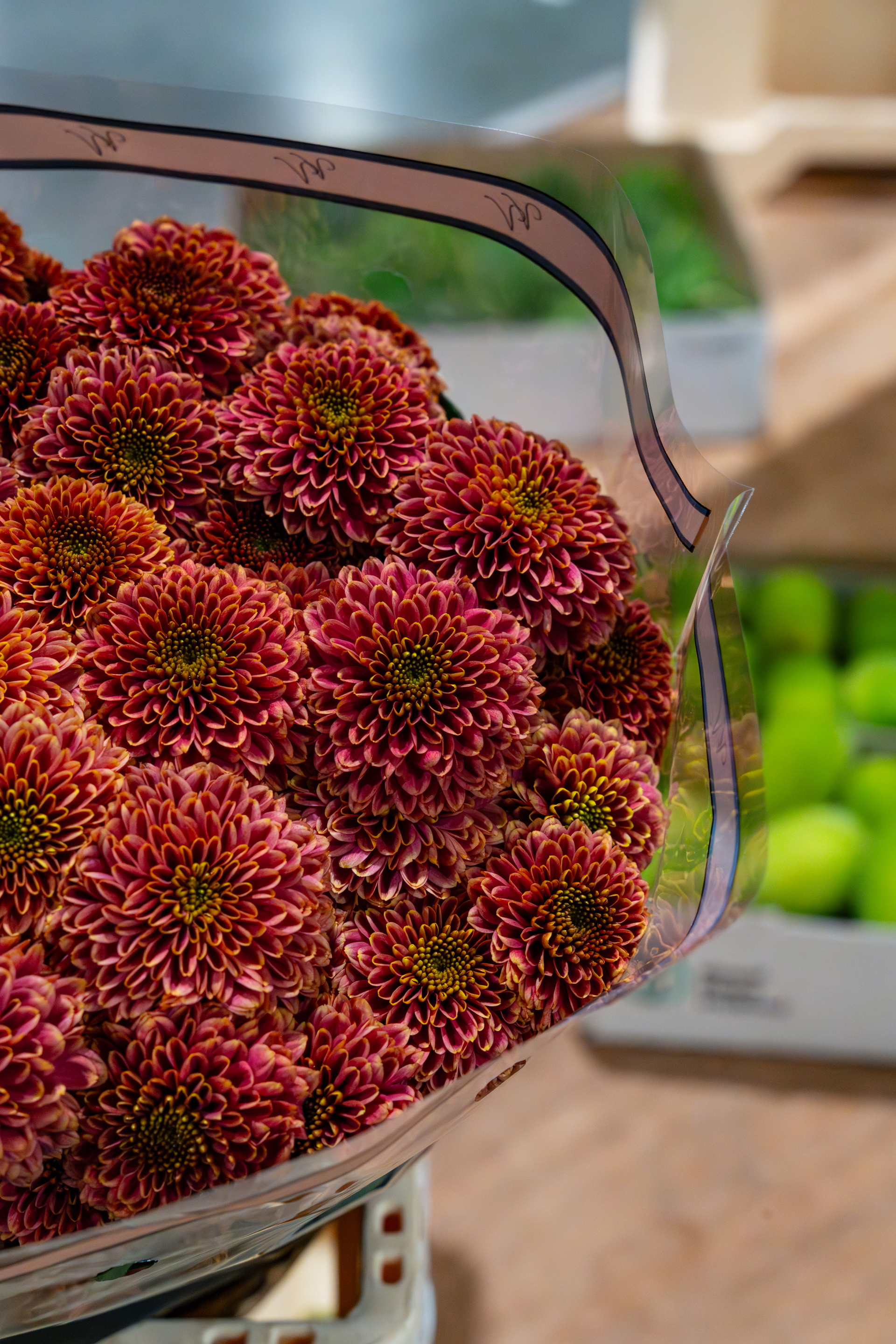 Close-up van rode rambutans in een glazen kom, met wazige achtergrond.