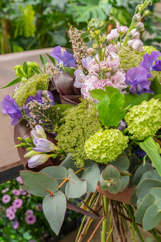 Kleurrijk boeket met paarse en groene bloemen op houten tafel