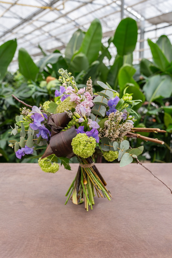 Kleurrijk boeket met paarse en groene bloemen op houten tafel in kas