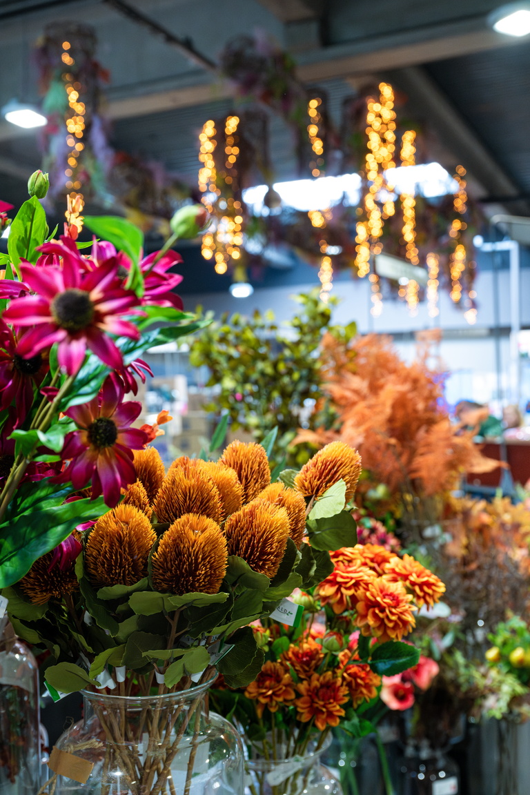 Kleurrijk bloemenboeket in winkel, met roze gerbera en oranje bloemen op voorgrond