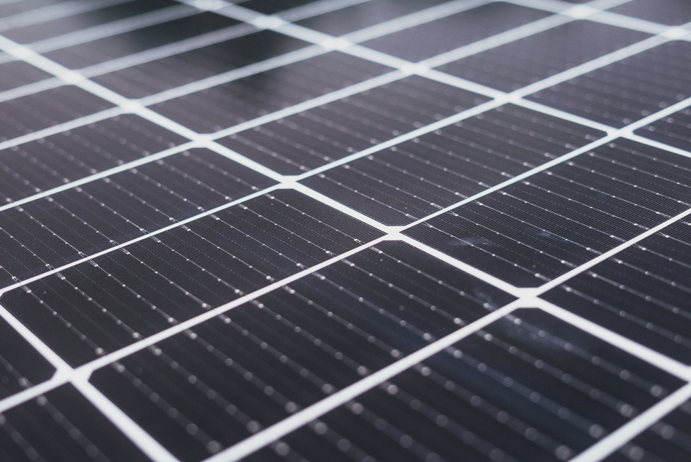Close-up van zonnepanelen op een dak, met diagonale lijnen in zwart en wit